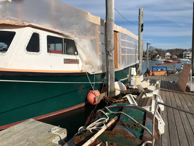 Gemma parts, including the green metal doors that keep the trawl net open, rest on the Eel Pond dock as the vessel undergoes renovation