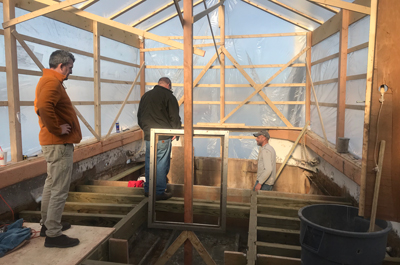 A plastic tarp protects the Gemma as its deck is replaced. From left are Dave Remsen, MBL's director of Marine Research Services; visitor Bill Mebane; and Doug Feeney of Chatham, Mass., who is rebuilding the deck.