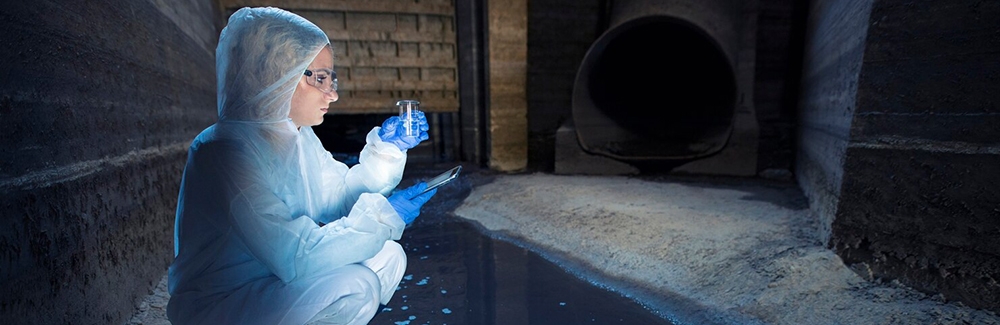 Scientist taking water samples from sewage system.