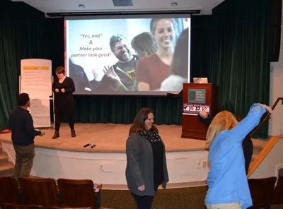 Elizabeth Bojsza of the Alan Alda Center for Communicating Science leads improvisation exercises in MBL's Lillie Auditorium. Photo by Diana Kenney