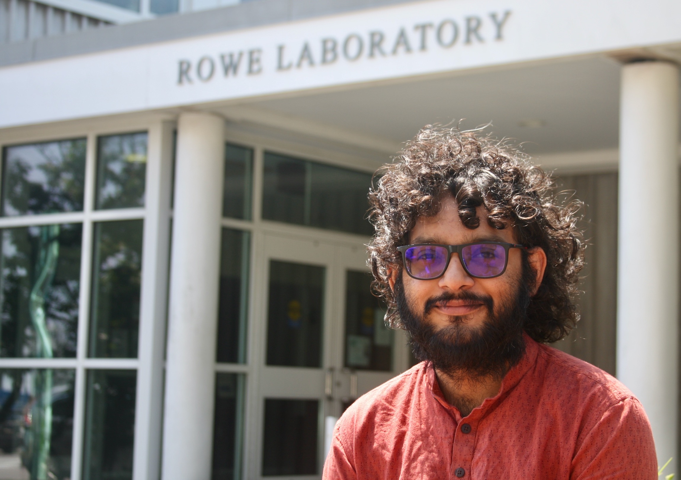 2024 Grass Fellow Aalok Varma sits outside Rowe Lab.