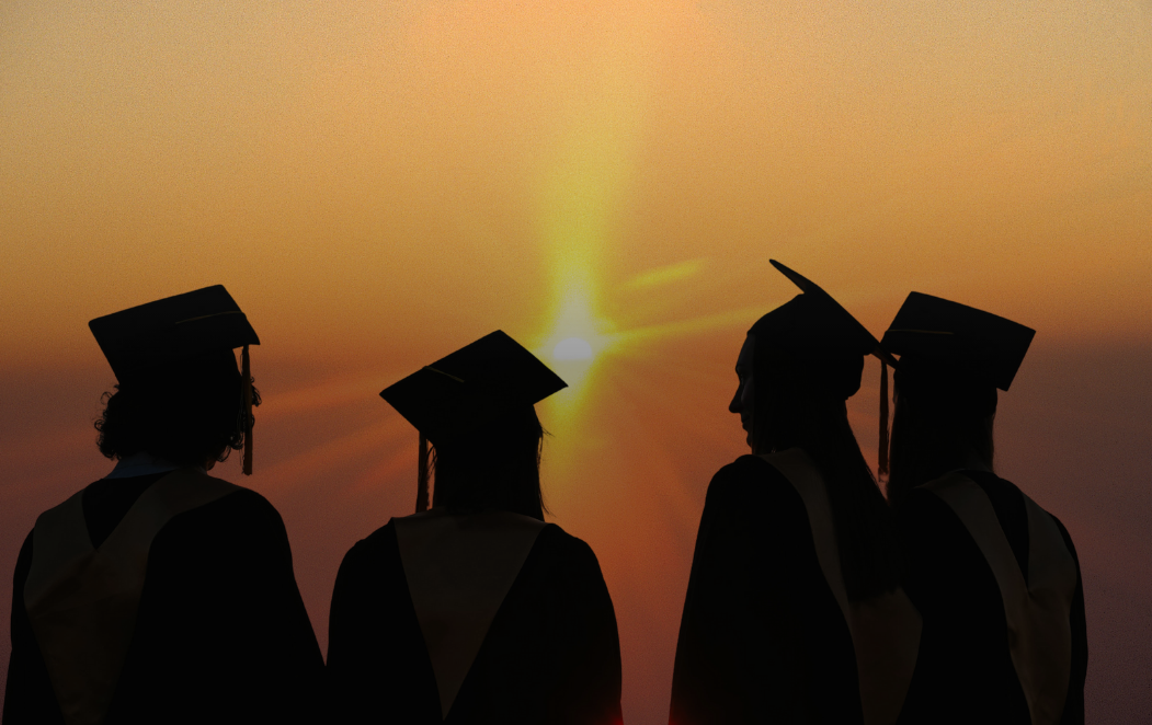 Graduates standing in front of the sun